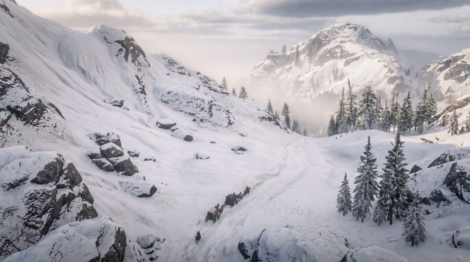 A snow-covered mountain pass under cloud, wind lifting powder off the ridges, a few pines in the drifts.