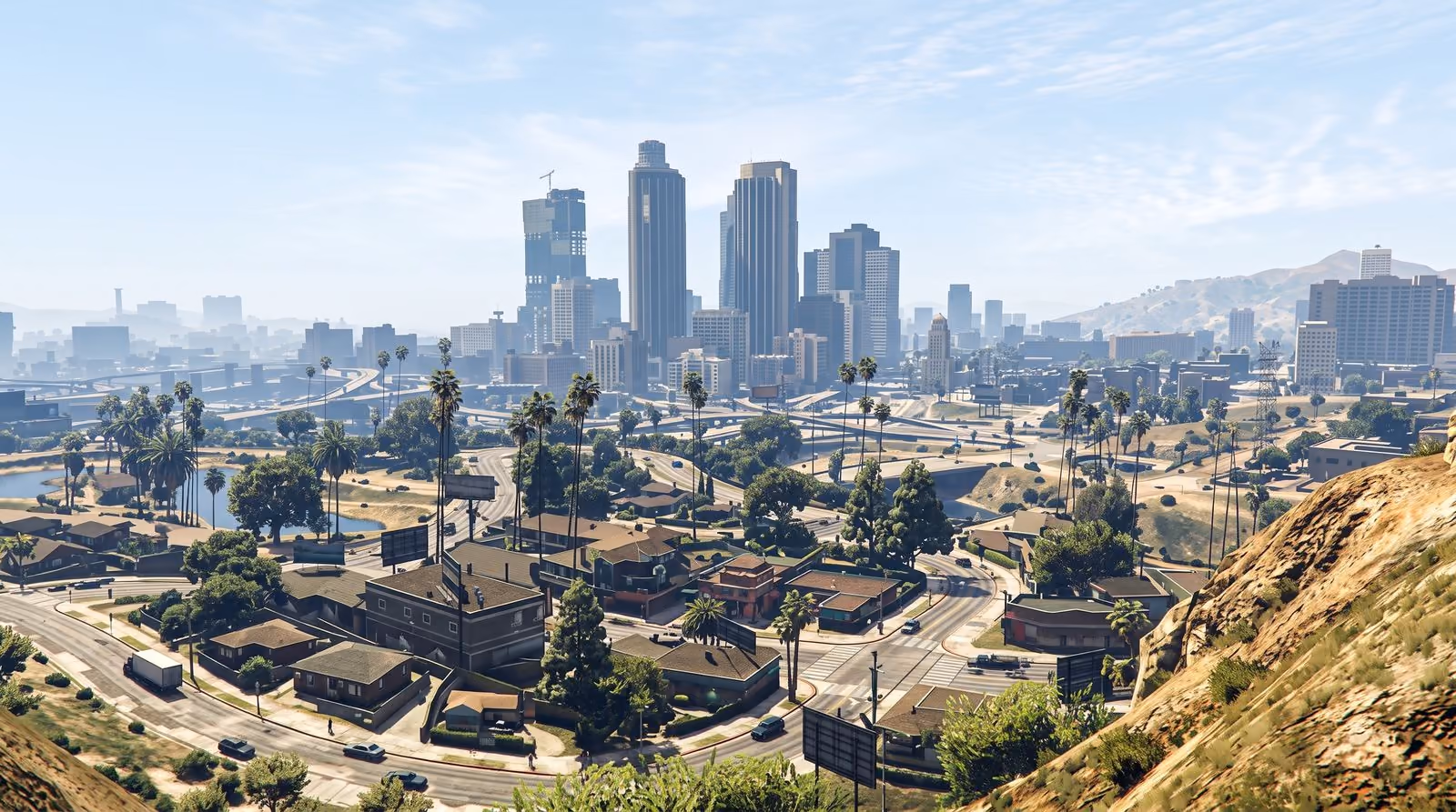 A wide daytime view over the suburbs to the downtown towers, haze softening the hills behind them.